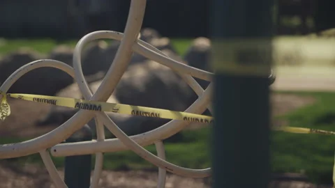 Rack focus on caution tape surrounding playground monkey bars 스톡 동영상 130392538