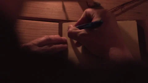Rack focus close up FHD shot of a man writing a thank you note in an old Stock Footage 137684045