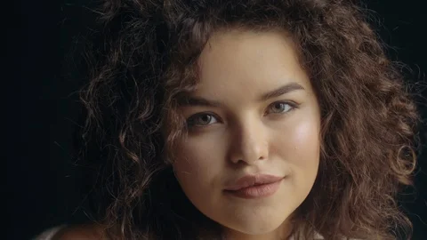 Rack focus: close up video portrait of young beutiful cute curly woman posing on Stock Footage 101498804