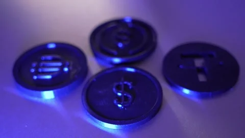Rack Focus on Cryptocurrency Coins Under Blue Neon Light Видео 348003412
