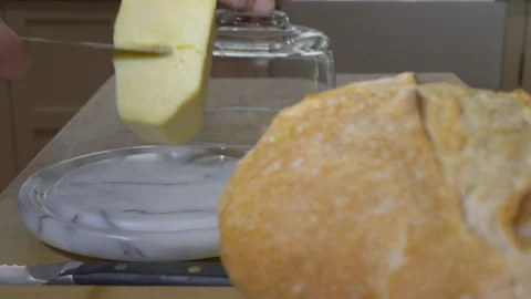 Rack focus / differential focus - bread loaf and taking cheese from glass dome. Stock Footage 139445973