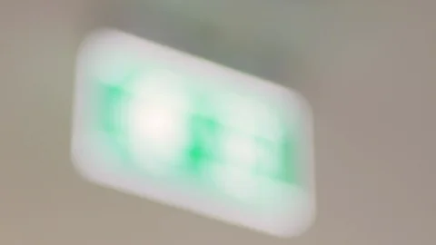 Rack focus of fire exit sign in modern building Stock-Footage 124650171
