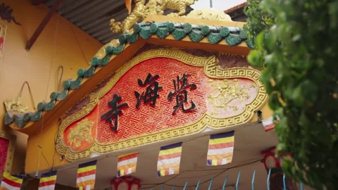 Rack Focus from Foliage to Buddhist Temple Entrance in Ho Chi Minh City, Vietnam 動画素材 343872565