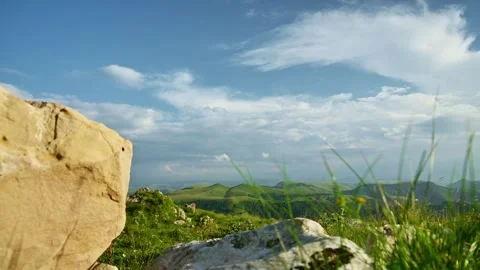 Rack focus from foreground grass to mountainous landscape 動画素材 343937295
