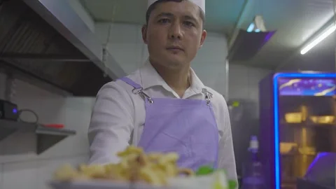 Rack focus from fried calamari dish to chef's face in Izmir Turkey 8 dec 2023 Video stock 332116193