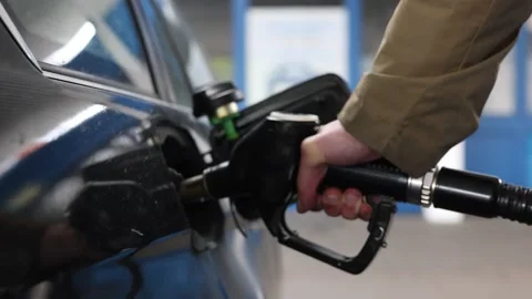 Rack focus on a hand holding the fuel nozzle Stock Footage 331844630