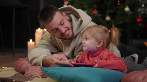 Rack focus from happy young father to cute little daughter playing video games Stock Footage 219915410