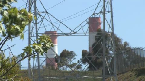 Rack Focus - Industrial Smoke Stacks With Electricity Tower - Tree in Foreground Stock Footage 4279767