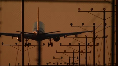Rack Focus From LAX Perimeter Fence to Descending Passenger Jet Vídeos de archivo 297844593