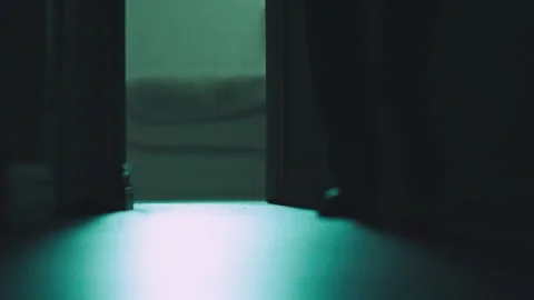 Rack focus of a man walking through an empty house at night, USA Stock Footage 236101821