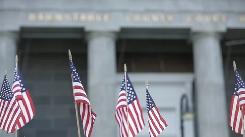 Rack focus from miniature American flags to Barnstable County Courthouse, day. Vídeo Stock 111019014
