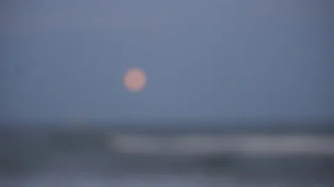 Rack focus to moon over sea Stock Footage 98909397
