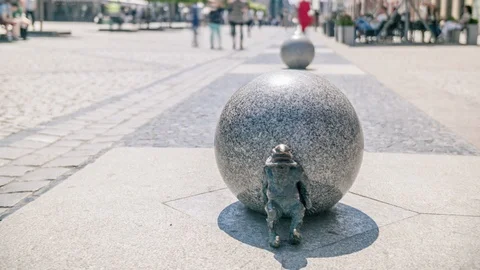 Rack focus motion timelapse of promenade and dwarf figure Stock Footage 101733877