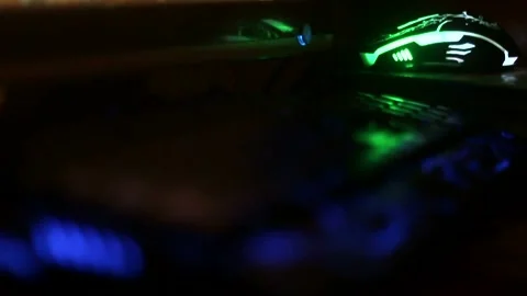 Rack focus from a multi-colored keyboard to a mouse close-up Видео 333706891