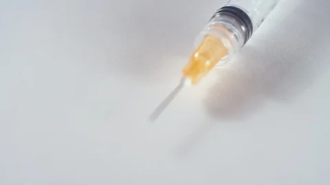 Rack focus of the needle of a syringe on a white background 스톡 동영상 119091651