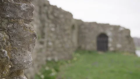 Rack focus from old castle walls to old iron door at castle Stock Footage 126549026