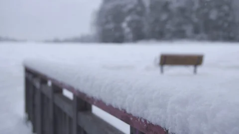Rack focus over snowy landscape with empty bench Stock Footage 102906242