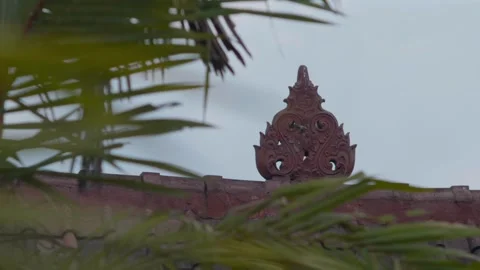 Rack Focus from Palm Tree Leaves to Decorative South East Asian Building Element Video stock 333819896