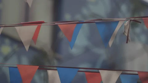 Rack focus of patriotic flags blowing in the wind, to a barbed wire fence 動画素材 130405138