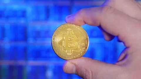 Rack focus portrait of Bitcoin gold coin being held between fingers Stock Footage 160950321