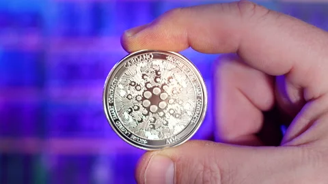 Rack focus portrait of Cardano ADA silver coin being held between fingers Stock Footage 160949250