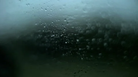 Rack focus POV rain droplets on car window driving in dark storm in country Stock Footage