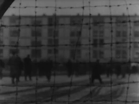 Rack focus prisoners through barbed wire Video stock 221532952
