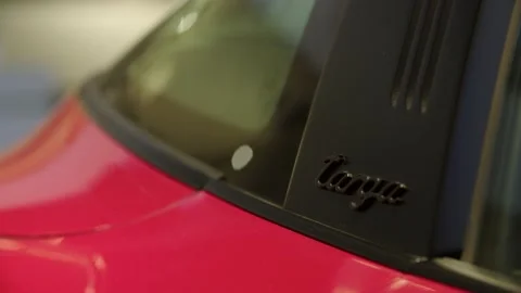 Rack focus, red and black porsche targa logo on side of car Stock Footage 229808950