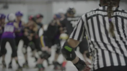 Rack focus from referee to roller derby players Stock Footage 232534143