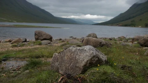 Rack focus from rock to view of the loch Stock Footage 104090272