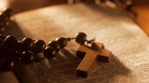 Rack focus from Rosary Beads to title of Gospel of Matthew Stock Footage 35060681