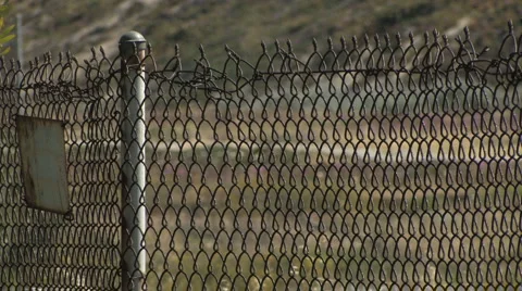 Rack Focus of Rusty Chain Link Fence to Field Stock Footage 4279790
