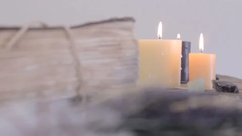 Rack focus on a sage bundle, old book and candles. 스톡 동영상 88604129