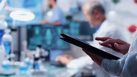 Rack focus from scientist digital tablet PC to researcher desk Stock Footage 111010541