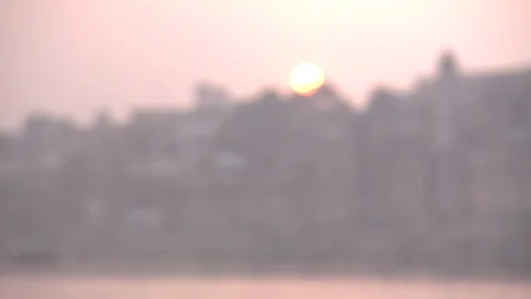 Rack focus to setting sun over Varanasi, India, and Ganges River Stock Footage 86760460