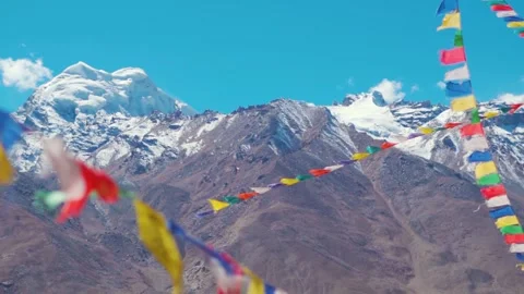 Rack focus shot of Buddhist prayer flags in front of the snowy Himalayas Stock Footage 277718961