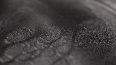 Rack focus shot of dark metallic steel paint with specialized sandy texture Stock Footage 327605634