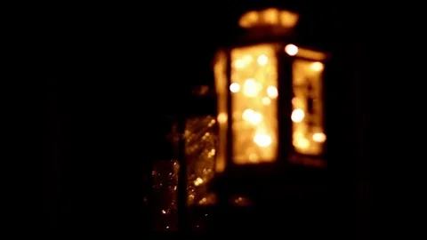 Rack focus shot of a decorative lantern with lights by a window Stock Footage 71118797