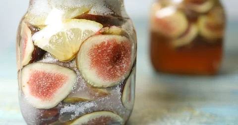 Rack focus shot of jars with sliced figs, lemon and sugar Stock-Footage 115932127