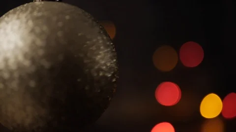 Rack focus on silver Christmas ball in foreground. Blinking Christmas lights Stock Footage 116544931