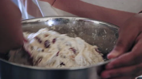 Rack focus to silver mixing bowl as raw bread dough is mixed with spatula Stock-Footage 194462545