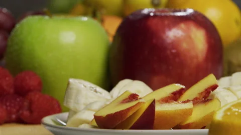Rack focus from sliced peaches and bananas to fresh apples - closeup shot Stock Footage 341268005