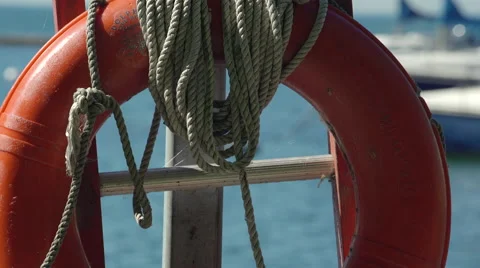 Rack focus slider shot of a life preserver ring and boats docked at marina. Stock Footage 53760257