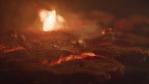 Rack focus on steaks on grill at night with flames Stock Footage 321377776