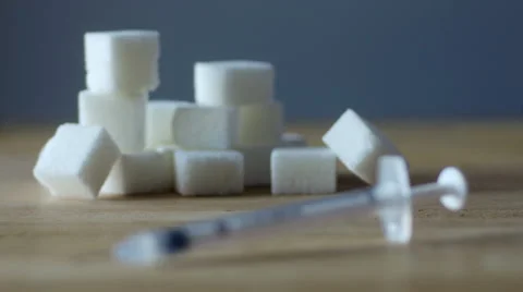 Rack focus from sugar cubes to insulin syringe Stock Footage 50115076