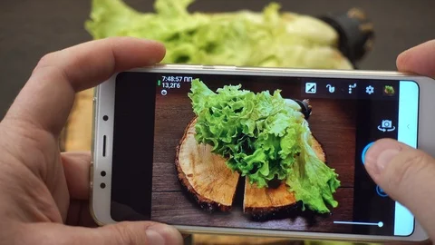 Rack focus. Taking picture of fresh lettuce leaves on wood board. Stock Footage 89034353