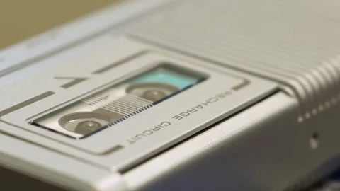 Rack Focus From Tape Spools Turning To Speaker In Microcassette Recorder Stock Footage 128440195