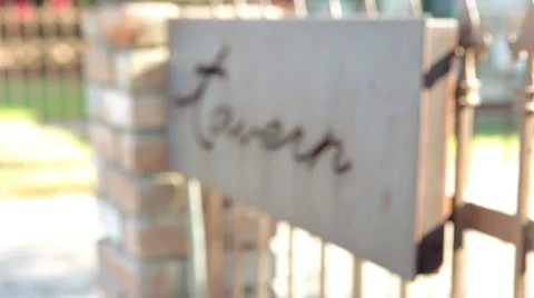 Rack Focus Tavern Sign on a Wrought Iron Fence Stock Footage 61839535