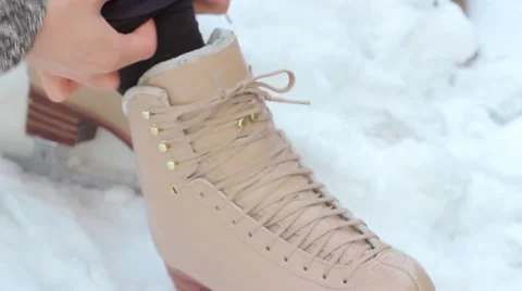 Rack Focus Tilt Up on Hands Lacing Up Figure Skates Stock Footage 65316083