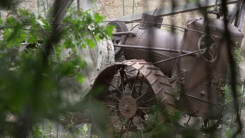 Rack focus from trees to an old rusty steam powered tractor. 動画素材 77528865